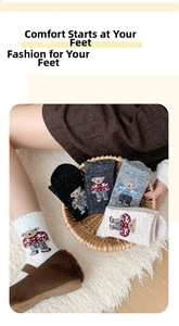 Detail of wool blend thermal socks with vintage bear embroidery and speckled texture