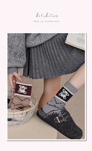 Detail von Wollsocken mit Retro-Bärenmuster und Fair-Isle-Strickstruktur für den Winter