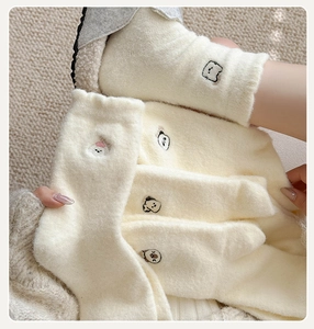 Gros plan de chaussettes d'hiver épaisses en peluche avec broderie d'animaux mignons