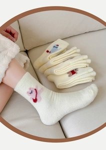 Détail de broderie animale sur chaussettes thermiques épaisses en polaire crème