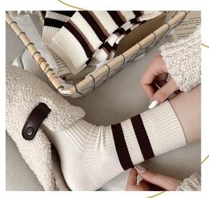 Détail de chaussettes en maille rayée marron avec des chaussures en polaire douce