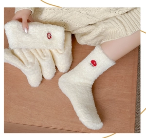 Gros plan de chaussettes thermiques blanches en peluche avec broderie fraise rouge