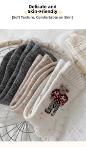 Detail of wool knit socks with cartoon bear pattern and speckled yarn texture