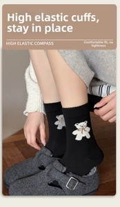 Détail de chaussettes en laine avec revers élastiques et ours 3D avec nœud papillon