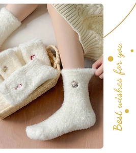 Détail de chaussettes blanches en velours de vison avec broderie cupcake et texture douce