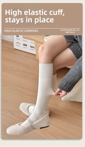 Close-up of cream white cashmere calf socks featuring elastic rib cuffs and ribbed texture