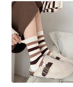 Texture de maille détaillée des chaussettes rayées mi-mollet en tons café et crème