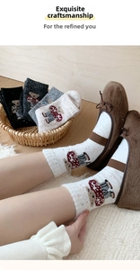 Close-up of knit wool socks with cute cartoon bear pattern and soft texture