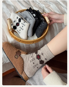 Detailed knit texture of vintage argyle wool socks in a cozy home setting with slippers
