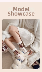 Gemütliche Stricksocken mit Bärenmuster und Schneeflocken in einer warmen Wohnumgebung
