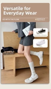 Detail of white ribbed cashmere socks paired with Mary Jane shoes for a cozy winter look