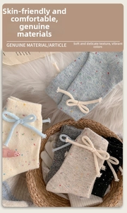 Detail view of thick wool confetti yarn socks with cute bow ties for winter warmth