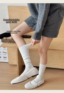 Detail of white rib-knit cashmere socks showing soft texture and elastic vertical stripes