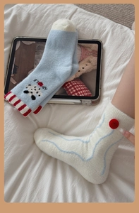 Close-up of thick coral fleece winter socks featuring cartoon patterns and soft plush texture