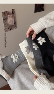 Détail de chaussettes en laine avec broderie d'ours mignonne et bords-côtes multicolores