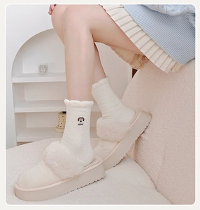 Detail of warm white thermal socks with happy puppy embroidery and plush slippers