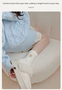 Close-up of cozy cream plush socks with bear embroidery and matching platform slippers