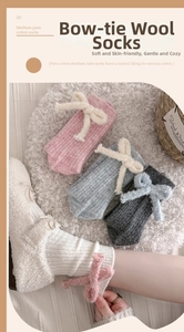 Detail of wool knit mid-tube socks featuring plush bow accents in four pastel colors