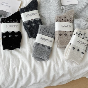 Five pairs of vintage argyle wool socks in neutral tones with premium packaging