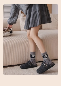Detail von Wollsocken mit weißem Bären-Jacquard und grauen Filz-Mules mit Schnallen