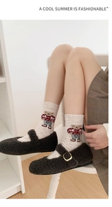 Detail of wool socks with cartoon bear pattern and plush Mary Jane shoes in soft light