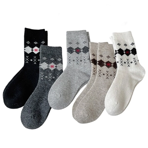 Five pairs of vintage argyle wool blend socks in assorted colors on white background