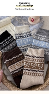 Close-up of five pairs of thick wool socks with bow patterns and geometric stripes