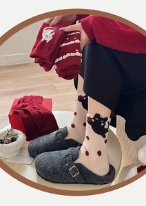 Detailed knit texture of wool socks featuring cute cartoon cats and warm winter patterns