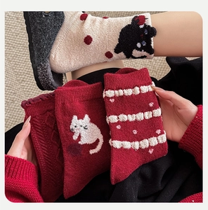 Detailed knit texture of cute cat pattern wool socks with red and beige colors