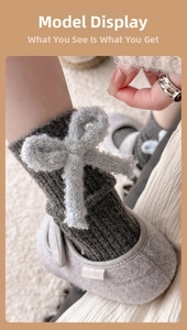 Detail of dark grey knit sock featuring a light blue plush faux fur bow decoration