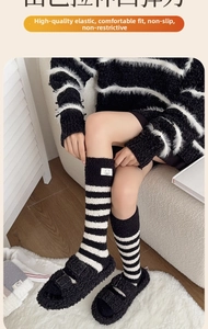 Close-up of black and white striped coral fleece socks with cute bear patch detail