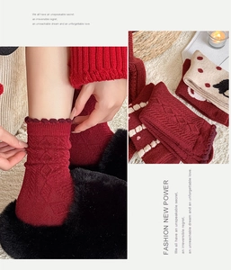 Detail of red wool socks with cartoon patterns, floral textures and ruffled edges
