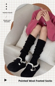 Detail showing thick wool knit leg warmers with speckled texture and stirrup design