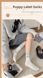 Detail of grey knitted mid-calf socks featuring a cute handmade cartoon fabric label