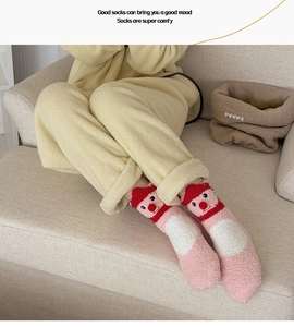 Detailaufnahme rosa Korallenfleece-Socken mit Elch-Design und weichen Bommeln