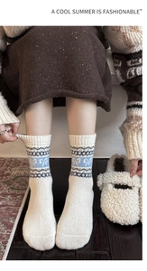 Detailed knit texture of wool socks featuring blue bow jacquard and geometric patterns