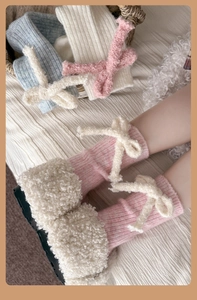 Detail of wool knit crew socks with plush bows and faux sheepskin trim in soft pink