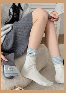 Close-up of cotton socks with handmade dog label and striped knit texture details