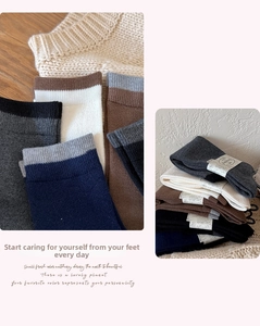 Detail of wool-blend calf socks with striped cuffs and thick knit texture in autumn colors