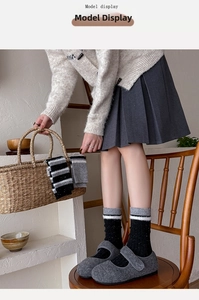 Detailed view of thick wool blend crew socks with vintage striped cuffs and snowflake dots