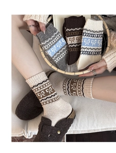 Close-up of vintage wool socks with bow patterns and thick Fair Isle knit texture