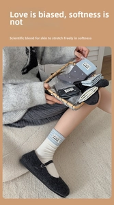 Detail of cute knitted crew socks featuring round cartoon patches and handmade labels