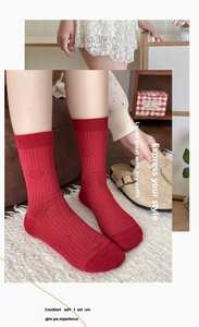 Detailed view of dark red mid-tube socks with vertical ribbing and cartoon cat patterns