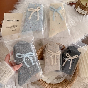Cozy wool knit socks with bow decor in five colors including blue, white, and grey