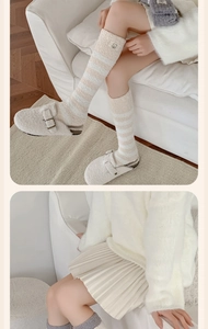 Detail of coral fleece socks featuring soft stripes and a cute bear patch decoration