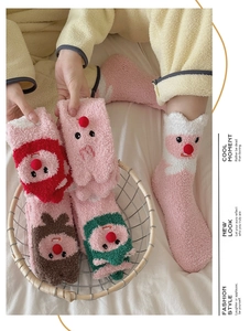 Detailansicht der rosa Korallenfleece-Socken mit niedlichen 3D-Bommel-Elch-Designs