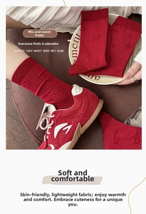Detail of red crew socks with floral relief pattern and elastic lock waist design