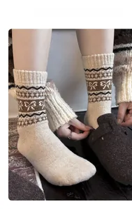 Close-up of wool blend Fair Isle crew socks with bow jacquard and brown felt clogs