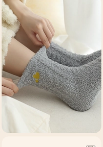 Detail of dark grey coral fleece socks with embroidered yellow heart for winter warmth