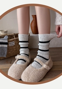 Detail of striped wool socks with knit texture worn with beige Mary Jane shoes